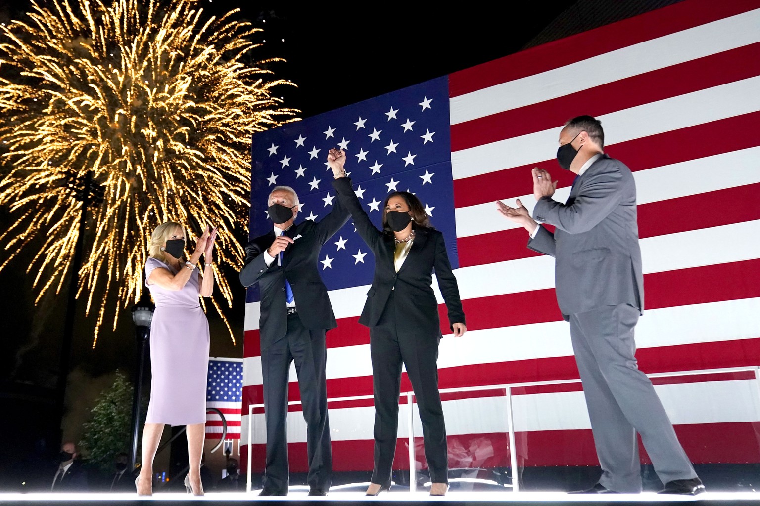Democratic presidential candidate former Vice President Joe Biden, with Democratic vice presidential candidate Sen. Kamala Harris, D-Calif., raise their arms up as fireworks go off in the background d ...