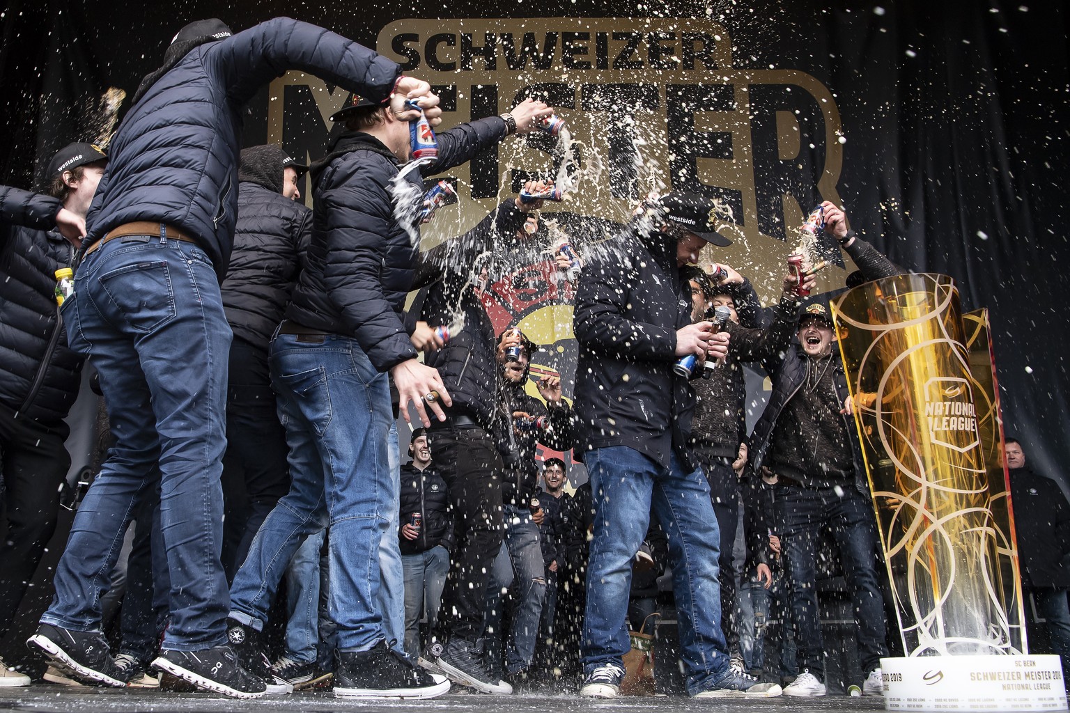 Berns Beat Gerber bekommt eine Bierdusche von seinen Teamkollegen, bei der Meisterfeier des SC Bern, am Samstag, 27. April 2019, auf dem Bundesplatz in Bern. (KEYSTONE/Anthony Anex)