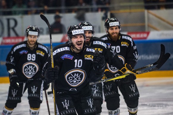 Lugano&#039;s player Alessio Bertaggia, center, celebrates the 2-0 goal, during the third match of the playoff final of the National League of the ice hockey Swiss Championship between the HC Lugano a ...