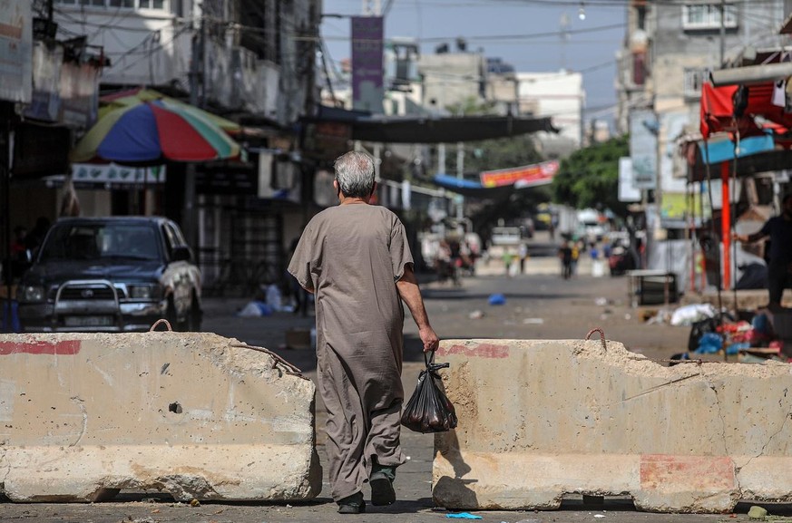 epa08634185 A Plaestinian man crosses after shopping for his family the concrete barriers used to isolate a road leading between Gaza and northern Gaza Strip amid the ongoing coronavirus COVID-19 pand ...