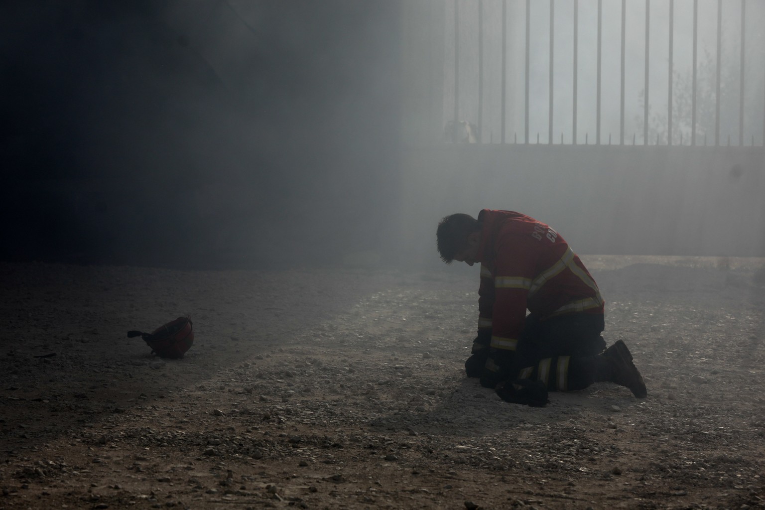 epaselect epa06268200 A firefighter kneels on the ground during a fire in Vila Nova de Poiares, Lousa, Portugal, 15 October 2017. The National Civil Protection Authority (ANPC) said it &#039;was the w ...
