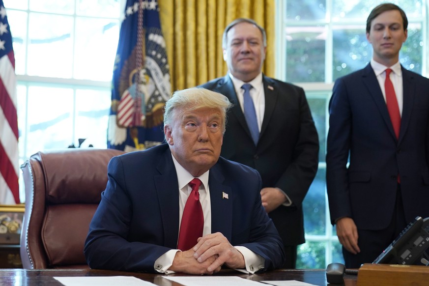 President Donald Trump listens while on a phone call with leaders of Sudan and Israel in the Oval Office of the White House, Friday, Oct. 23, 2020, in Washington. Secretary of State Mike Pompeo and Ja ...