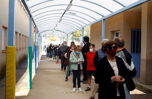 epa09176752 Voters wait in a long queue outside a polling station during Madrid&#039;s regional election, in the town of Galapagar, Madrid, Spain, 04 May 2021. Some 5.11 million citizens are called to ...