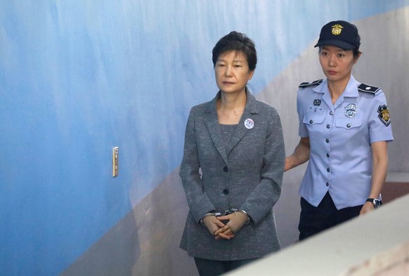 epa08936551 (FILE) - Former South Korean President Park Geun-hye (L) is escorted to a courtroom to stand trial on alleged bribery, abuse of power and leaks of government secrets, in Seoul, South Korea ...
