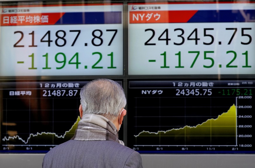 A man looks at an electronic stock indicator of a securities firm in Tokyo, Tuesday, Feb. 6, 2018. Shares tumbled in Asia on Tuesday after a wild day for U.S. markets that resulted in the biggest drop ...