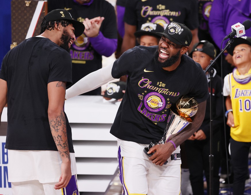 epa08736876 Los Angeles Lakers forward LeBron James (R) holds the MVP trophy as he ceebrates with Anthony Davis (L) after defeating the Miami Heat to win the 2020 NBA Finals at the ESPN Wide World of  ...