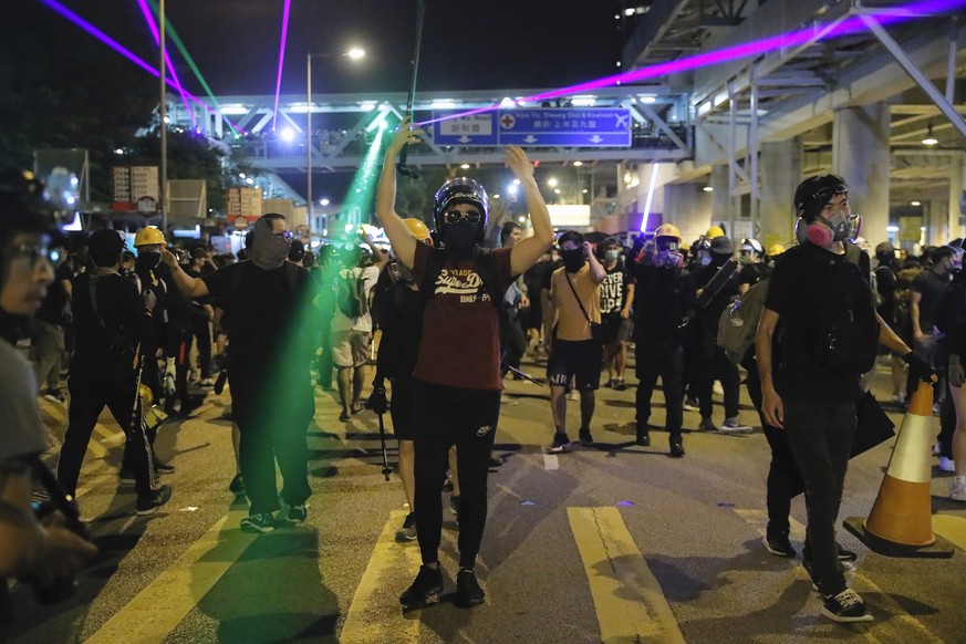 Demonstrators shine laser pointers outside the Yuen Long MTR station during a protest in Hong Kong, Wednesday, Aug. 21, 2019. Hong Kong riot police faced off briefly with protesters occupying a suburb ...