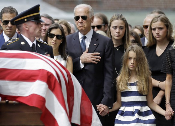 Vice President Joe Biden, accompanied by his family, holds his hand over his heart as he watches an honor guard carry a casket containing the remains of his son, former Delaware Attorney General Beau  ...