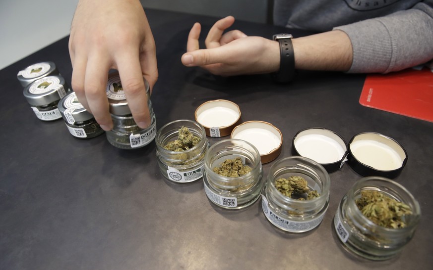 In this Thursday, June 6, 2019 a shop assistant opens jars of cannabis buds at a cannabis light store in Milan, Italy. Interior Minister Matteo Salvini has been an outspoken opponent of the marijuana  ...