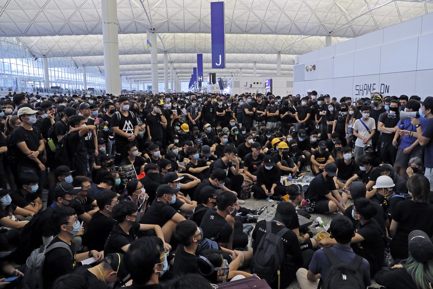 Protesters gather near an information board during a protest at the Hong Kong International Airport, Monday, Aug. 12, 2019. One of the world&#039;s busiest airports canceled all flights after thousand ...
