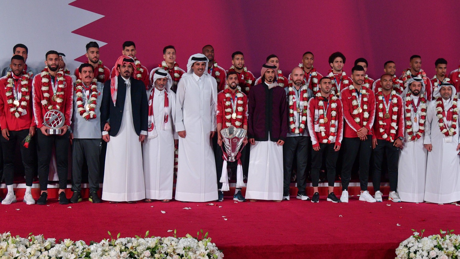 (190203) -- DOHA, Feb. 3, 2019 -- Qatar s Emir Sheikh Tamim bin Hamad Al Thani (C) welcomes the Qatari national soccer team upon arrival at Doha International Airport in Doha, Qatar on Feb. 2, 2019. Q ...