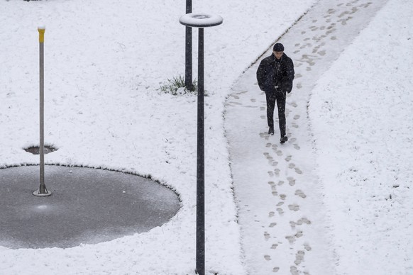 Une personne marche sous la neige fraichement tombee, ce jeudi 4 avril 2019 a Geneve. (KEYSTONE/Martial Trezzini)