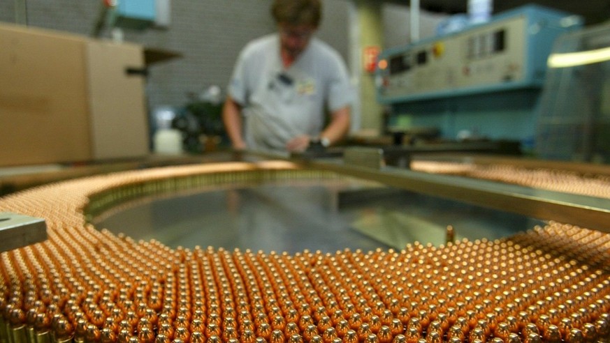 Ein Arbeiter kontrolliert am Donnerstag, 25. Juli 2002 in Thun in der Munitionsabteilung des Ruestungskonzerns Ruag, der Ruag Munition, die Herstellung von 9-Millimeter-Patronen. Die Ruag kuendigte am ...