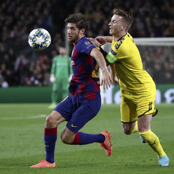 Barcelona&#039;s Sergi Roberto vies for the ball with Dortmund&#039;s Marco Reus, right, during a Champions League group F soccer match between Barcelona and Borussia Dortmund at the Camp Nou stadium  ...