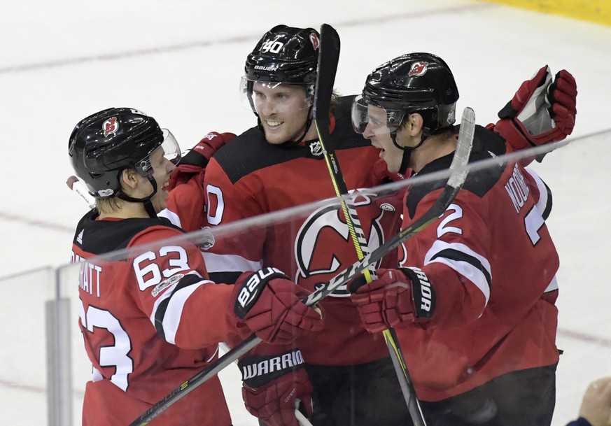 New Jersey Devils defenseman John Moore celebrates his goal with left wing Jesper Bratt (63) and center Blake Coleman (40) during the third period of an NHL hockey game Saturday, Oct. 7, 2017, in Newa ...