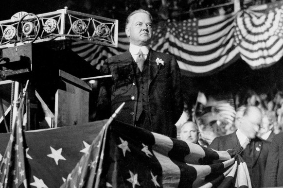 FILE - In this Oct. 22, 1928 file photo, Republican presidential candidate Herbert Hoover delivers an address from a U.S. flag-draped podium in Madison Square Garden in New York. (AP Photo)