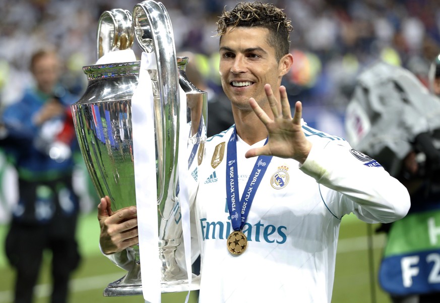 FILE - In this Saturday, May 26, 2018 file photo Real Madrid&#039;s Cristiano Ronaldo celebrates with the trophy after winning the Champions League Final soccer match between Real Madrid and Liverpool ...