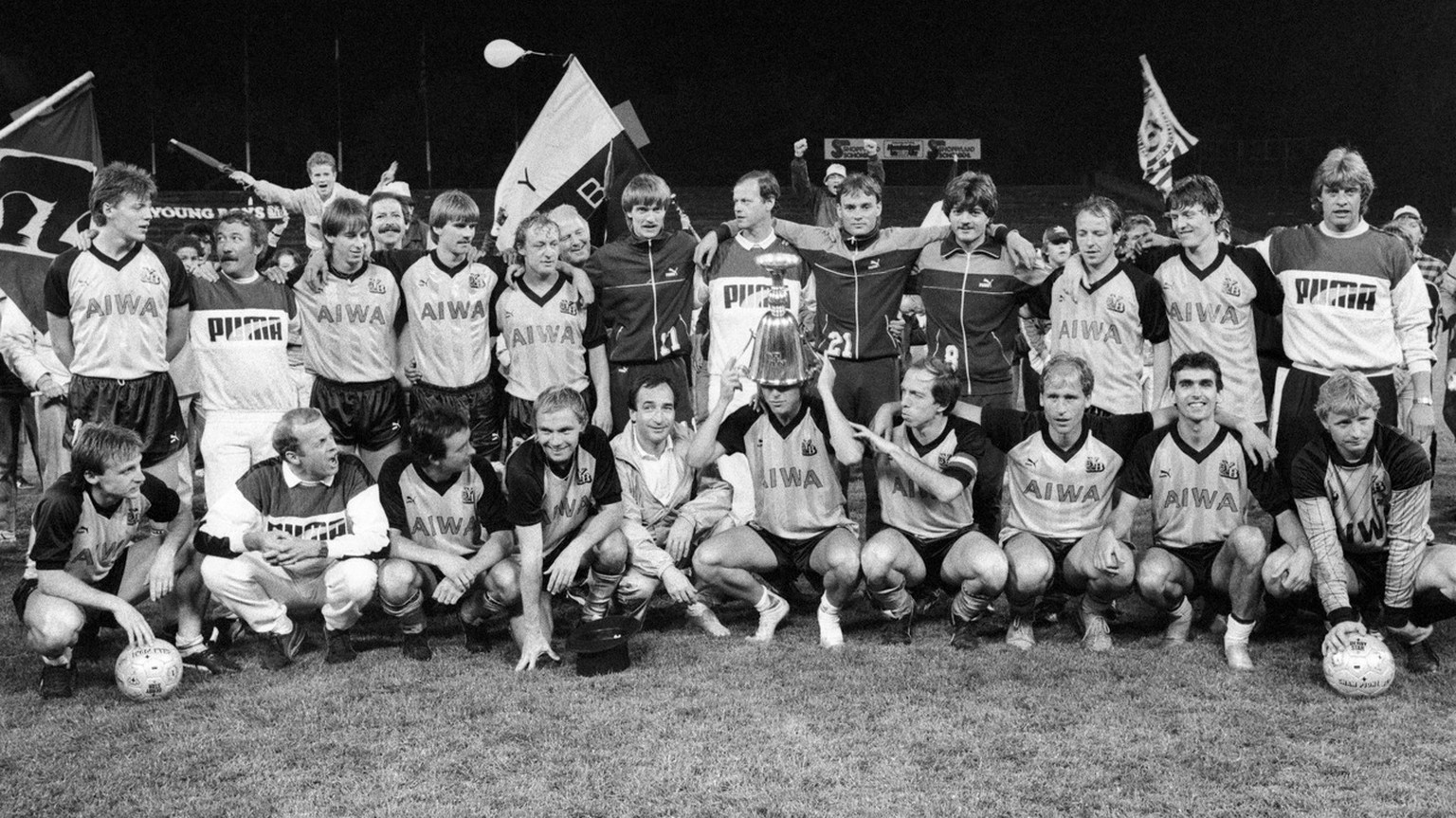 The team of the Young Boys celebrated the victory of the championship in Berne on 27 May 1986. Lars Lunde, in the middle, is enthusiastically pushing the championship cup over his head. (KEYSTONE/Str) ...