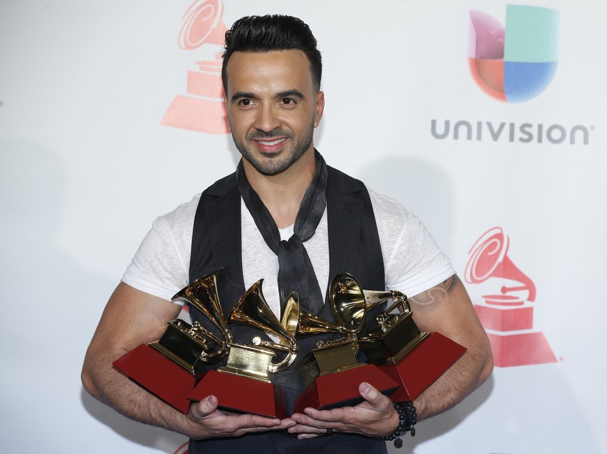 Luis Fonsi poses in the press room with the awards for best urban/fusion/performance, best short form music video, record of the year, and song of the year for &quot;Despacito&quot; at the 18th annual ...