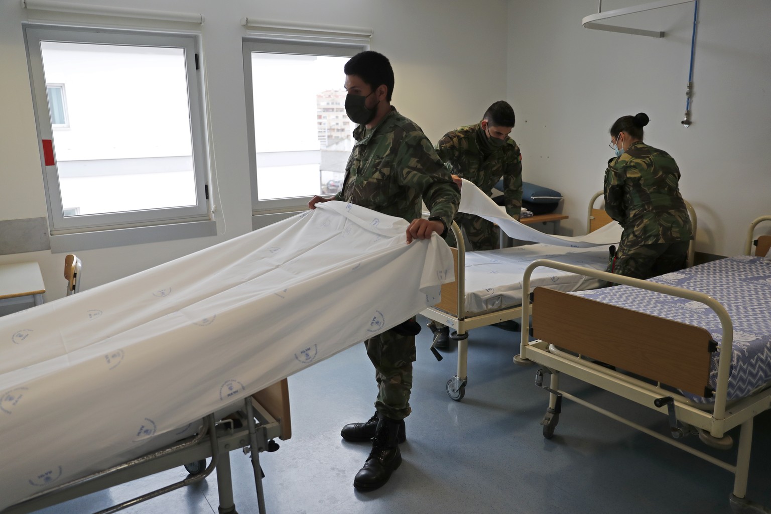 Soldiers prepare beds in a new COVID-19 ward being set up at the Military Hospital in Lisbon, Tuesday, Jan. 26, 2021. The military hospital is expanding it&#039;s number of beds available to take COVI ...