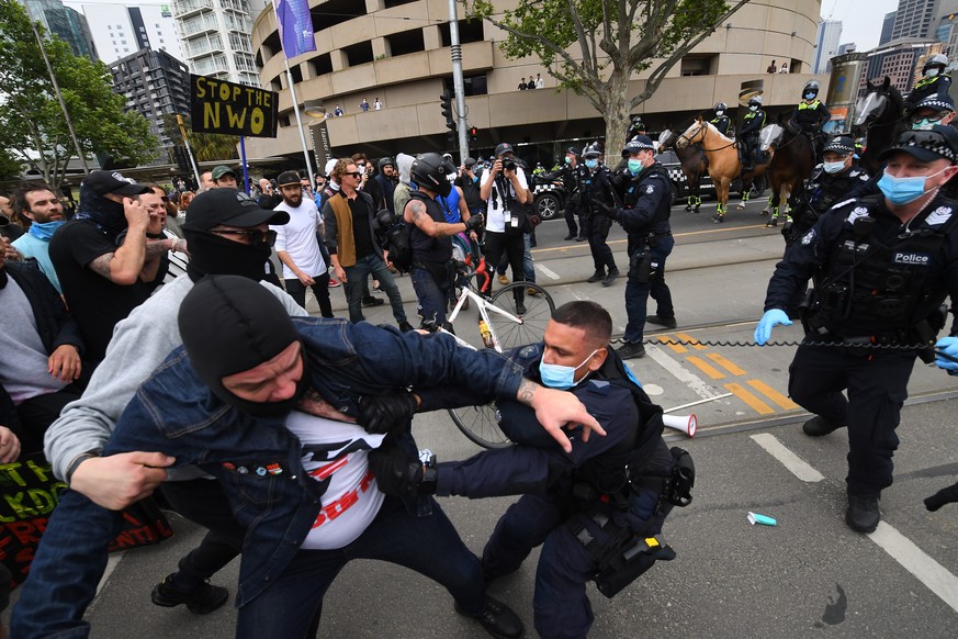 epa08766961 Protesters clash with police officers during an anti-lockdown protest in Melbourne, Victoria, Australia, 23 October 2020. An anti-lockdown protest is underway in Melbourne where police hav ...