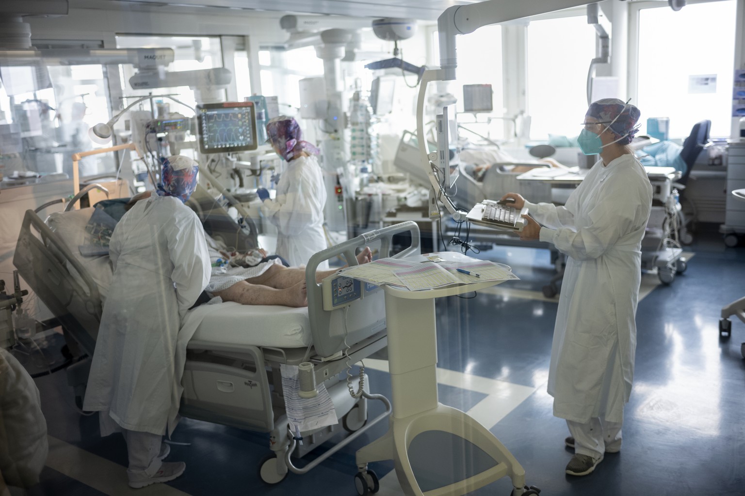 Pflegepersonal kuemmert sich um einen Covid-19 Patienten, in der Abteilung Intensivpflege im HFR Freiburg Kantonsspital, am Donnerstag, 26. November 2020 in Fribourg. (KEYSTONE/Alessandro della Valle)