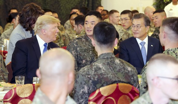 epa06312713 South Korean President Moon Jae-in (C-R) and US President Donald J. Trump (C-L) eat lunch with South Korean and US soldiers at Camp Humphreys in Pyeongtaek, south of Seoul, South Korea, 07 ...