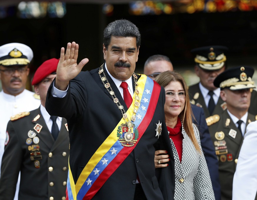 FILE- In this May 24, 2018 file photo, Venezuela&#039;s President Nicolas Maduro and first lady Cilia Flores greets the media as they arrive to a military parade at Fort Tiuna in Caracas, Venezuela. U ...