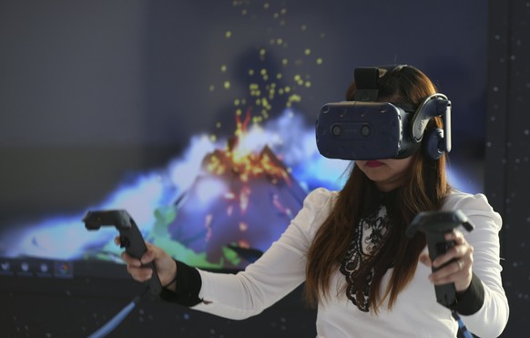 epa06662588 A woman experiences the new virtual reality (VR) headset &#039;HTC Vive Pro&#039; during its launch event at Burj Khalifa in Dubai, United Arab Emirates, 11 April 2018. EPA/ALI HAIDER