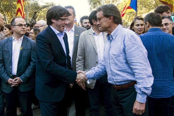 epa06280766 Catalan regional President, Carles Puigdemont (L) and former regional president Artur Mas (R) shake hand as they attend the protest called against the imprisonment of Catalan pro-independe ...