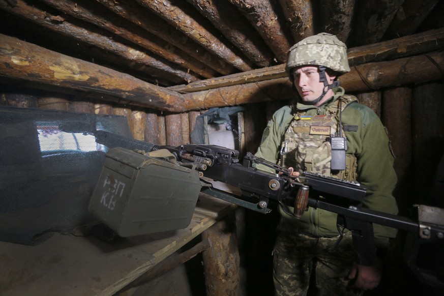A Ukrainian soldier is seen at fighting positions on the line of separation from pro-Russian rebels near Luhansk, Ukraine, Friday, April 16, 2021. Growing cease-fire violations and a massive Russian m ...