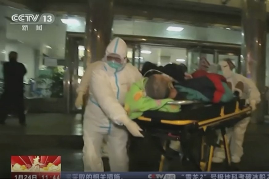 In this Thursday, Jan. 23, 2020, image from China&#039;s CCTV video, a patient is carried on a stretcher to an ambulance by medical workers in protective suits in Wuhan, China. China is swiftly buildi ...