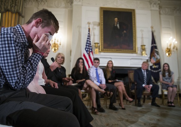 epa06551639 Marjory Stoneman Douglas High School shooting survivor Samuel Zeif (L) cries after delivering remarks as US President Donald J. Trump listens during a listening session with high school st ...