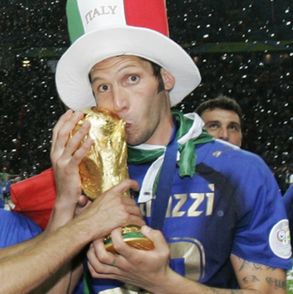 Italy&#039;s Marco Materazzi kisses the World Cup trophy, as Fabio Grosso, left, and other teammates look on, after the final of the soccer World Cup between Italy and France in the Olympic Stadium in ...