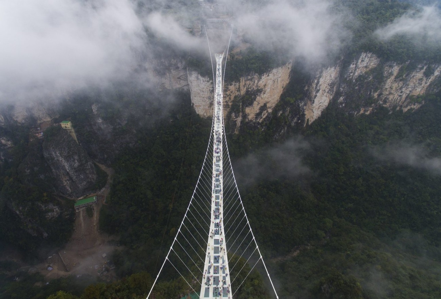 epa05593548 An aerial view of the Zhangjiajie Grand Canyon Glass Bridge in Zhangjiajie City, Hunan Province, central China, 20 October 2016. Claimed by China to be the longest and highest glass bridge ...