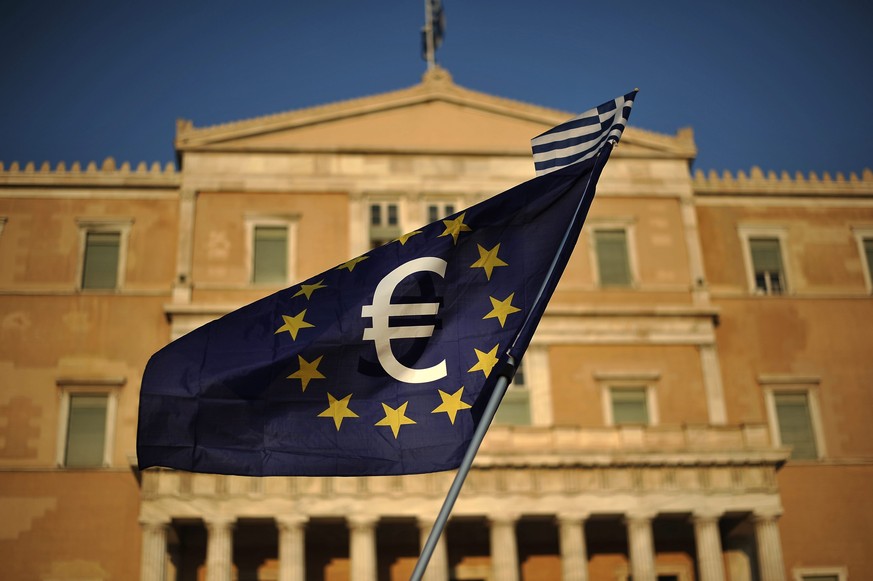 epa04839306 A demonstrator waves a European flag with the euro sign seen in the center during a pro euro rally in front of the Greek Parliament in Athens Greece, 09 July 2015.Eurogroup President Jeroe ...