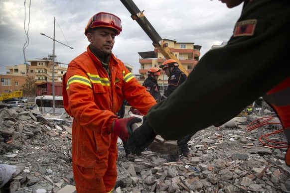 In this photo taken on Thursday, Nov. 28, 2019, rescuers from Turkey search with their Albanian colleagues at a collapsed building after the 6.4-magnitude earthquake in Durres, western Albania.In the  ...