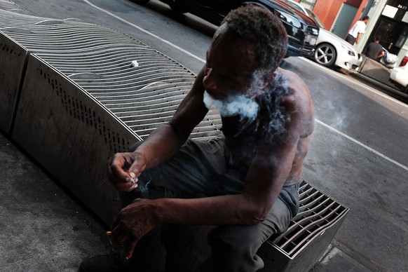 NEW YORK, NY - AUGUST 31: A man smokes K2 or &#039;Spice&#039;, a synthetic marijuana drug, in an area which has witnessed an explosion in the use of K2 in East Harlem on August 31, 2015 in New York C ...