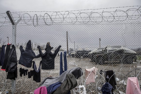 epa05202710 Refugees dry clothes at a barbed-wire fence in a camp at the border between Greece and the Former Yugoslav Republic of Macedonia (FYROM), near Idomeni, northern Greece, 09 March 2016. Gree ...