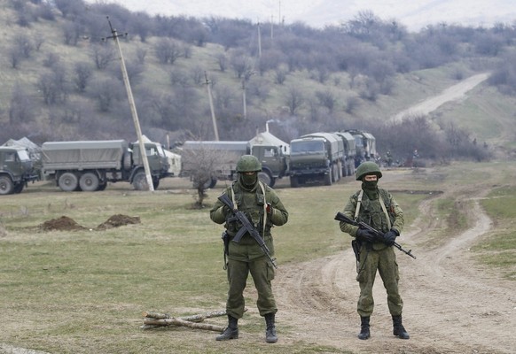 epa04121666 Armed men in military uniform are seen outside the territory of Ukrainian military unit in the village of Perevalnoye, outside Simferopol, Ukraine, 12 March 2014. Crimea&#039;s secessionis ...