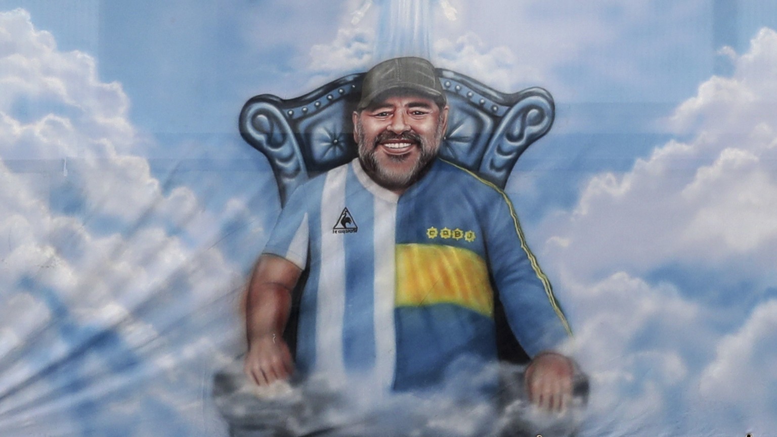 A flag with the image of Diego Maradona wearing the Boca Juniors and Argentine T-shirt hangs from the stands during a local league soccer match between of Boca Juniors and of River Plate at the Bombon ...