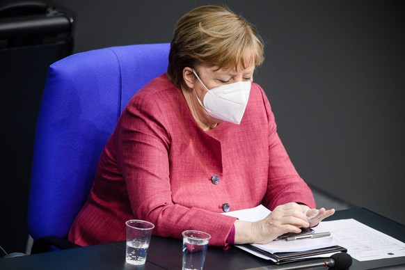 epa09138819 German Chancellor Angela Merkel wears a face mask as she looks on during a session of the German parliament Bundestag in Berlin, Germany, 16 April 2021. The German parliament consults abou ...