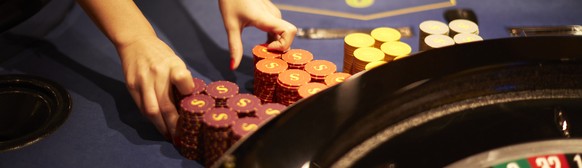 ZUM SWISS CASINO ZUERICH STELLEN WIR IHNEN HEUTE, DONNERSTAG, 12. OKTOBER 2015, FOLGENDES NEUES BILDMATERIAL ZUR VERFUEGUNG --- A person prepares a roulette table at the Swiss Casino Zuerich in Zurich ...