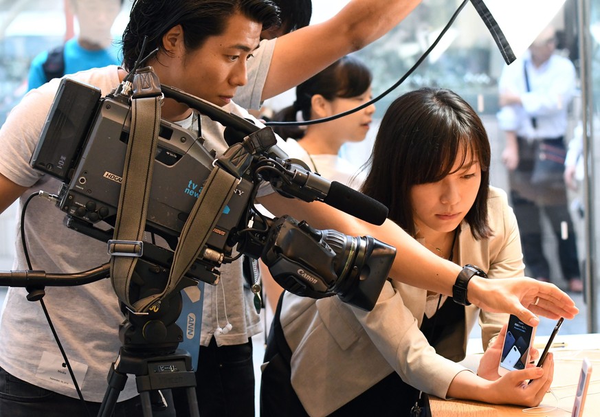 epa05541654 A TV crew films Apple&#039;s new iPhone 7 and iPhone 7 Plus at the Apple Store of Omotesando shopping district in Tokyo, Japan, 16 September 2016. Some Apple fans have been lining up for t ...