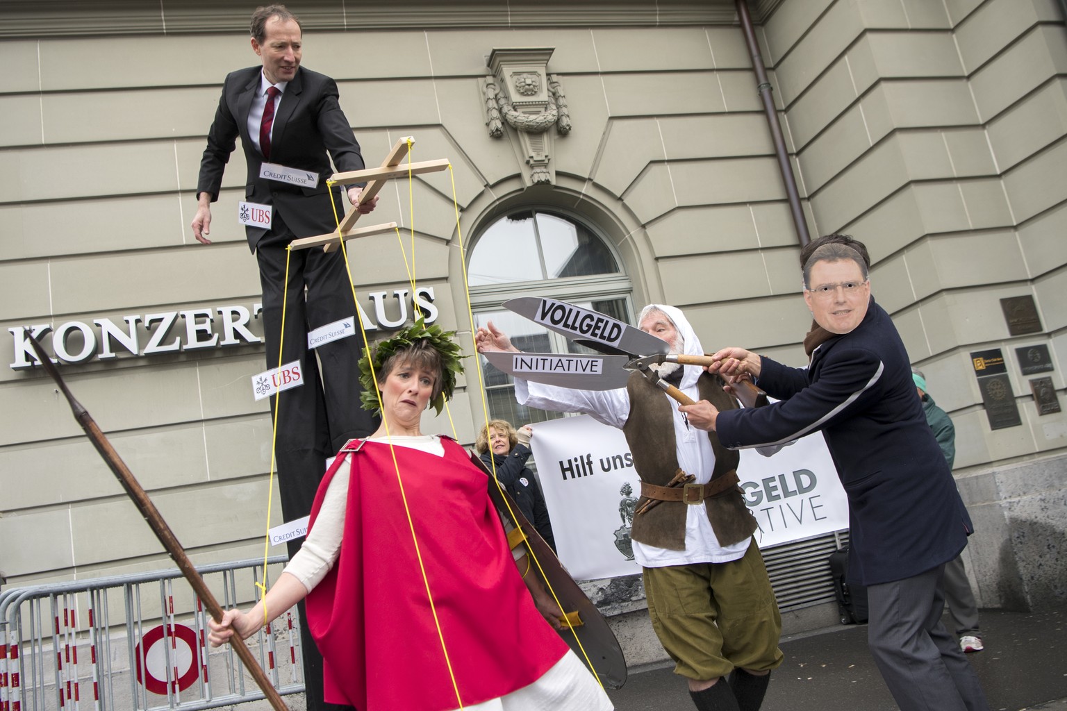 Aktivisten des Komitees &quot;Vollgeld-Initiative&quot; protestieren mit einer Marionetten-Helvetia, Mitte, und einer Maske von SNB Praesident Thomas Jordan, rechts, vor der 109. SNB Generalversammlun ...
