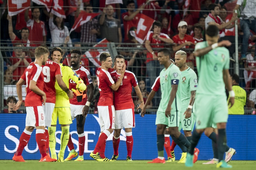 Swiss soccer players, left, celebrates the victory next to Portugal&#039;s soccer players, right, during the 2018 Fifa World Cup Russia group B qualification soccer match between Switzerland and Portu ...