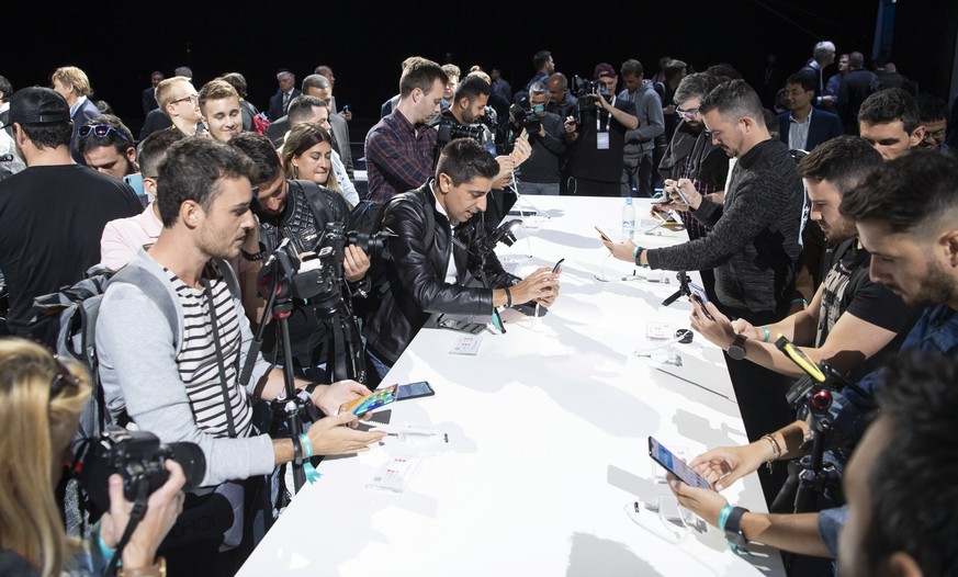 epa07853482 People inspect the new Huawei Mate 30 and 30 Pro smartphones after the presentation in Munich, Germany, 19 September 2019. EPA/LUKAS BARTH-TUTTAS
