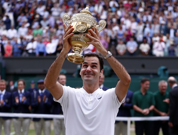 epa06091383 Roger Federer of Switzerland hoists the championship trophy following his victory over Marin Cilic of Croatia in the men&#039;s final of the Wimbledon Championships at the All England Lawn ...