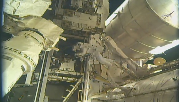 This photo provided by NASA, astronauts Andrew Morgan and Nick Hague (not seen) begin to install a docking port delivered by SpaceX last month outside the International Space Station on Wednesday, Aug ...