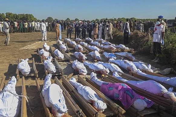 epa08851188 Nigerians attend a mass burial of farm workers killed in an attack at Zabarmari, Borno State, northeast Nigeria, 29 November 2020. According to reports, 43 farm workers in Zabarmari were k ...